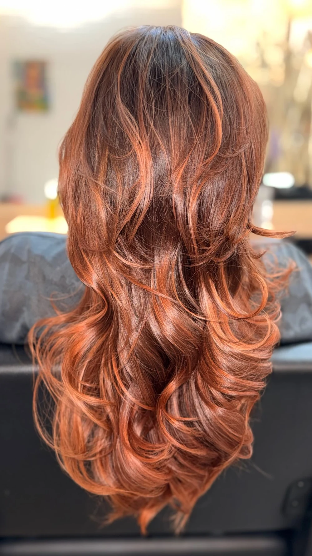 Melena cobriza con capas y ondas vista de espaldas.
