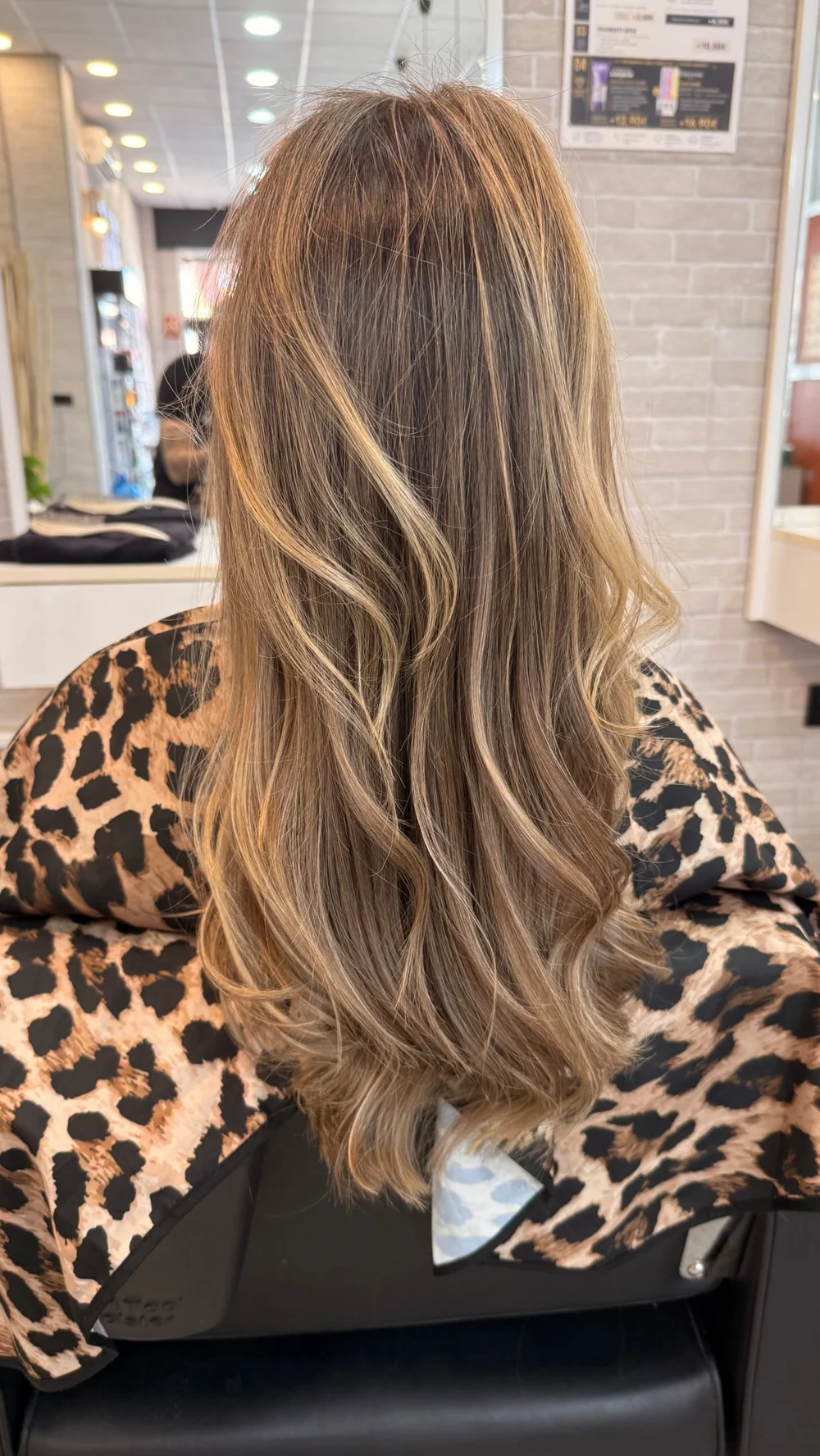 Melena castaña con mechas claras y ondas vista de espaldas.